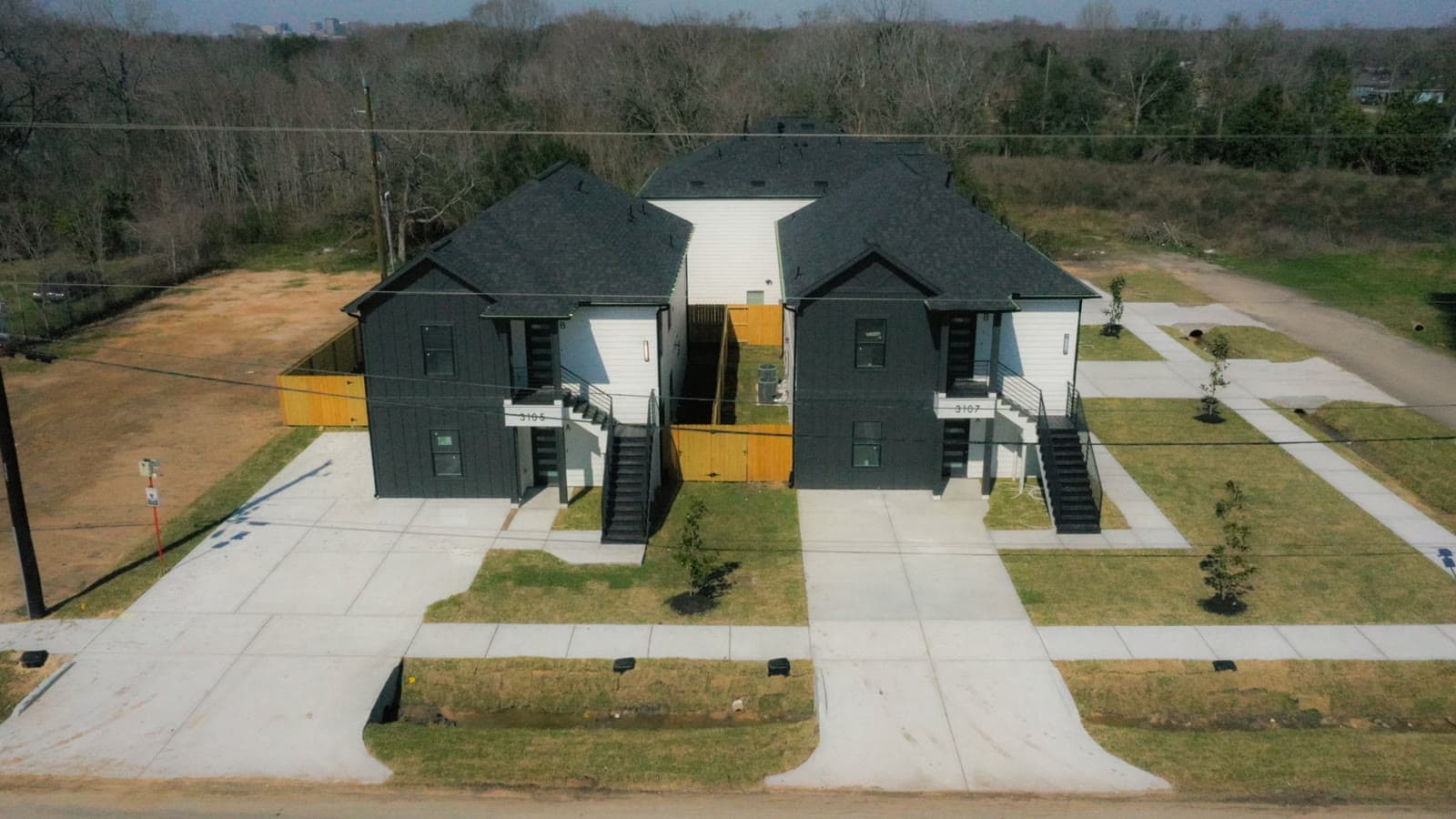 3105 & 3107 Grassmere — Two duplexes delivered side by side on one site — four rental doors, completed drives, sod, and landscaping from a single development.